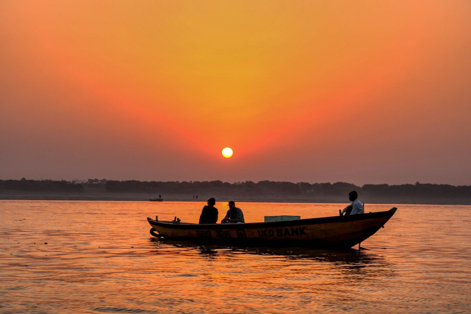 A boat on a calm river at sunset